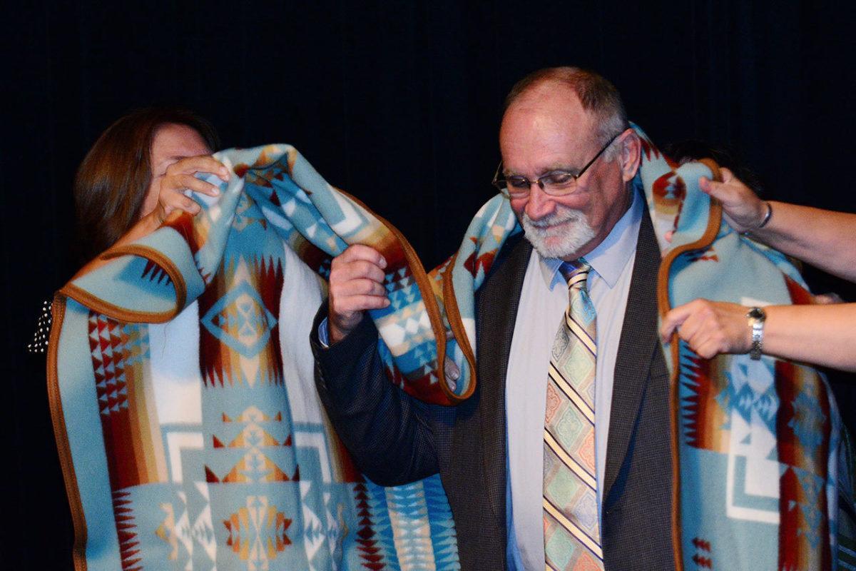 Jamestown S’Klallam tribal members wrap a blanket around state Sen. Jim Hargrove, honoring him for his more than 30 years in the state Legislature, during the Clallam County Democrats’ Franklin & Eleanor Roosevelt Dinner at 7 Cedars Casino on Saturday. (Jesse Major/Peninsula Daily News)