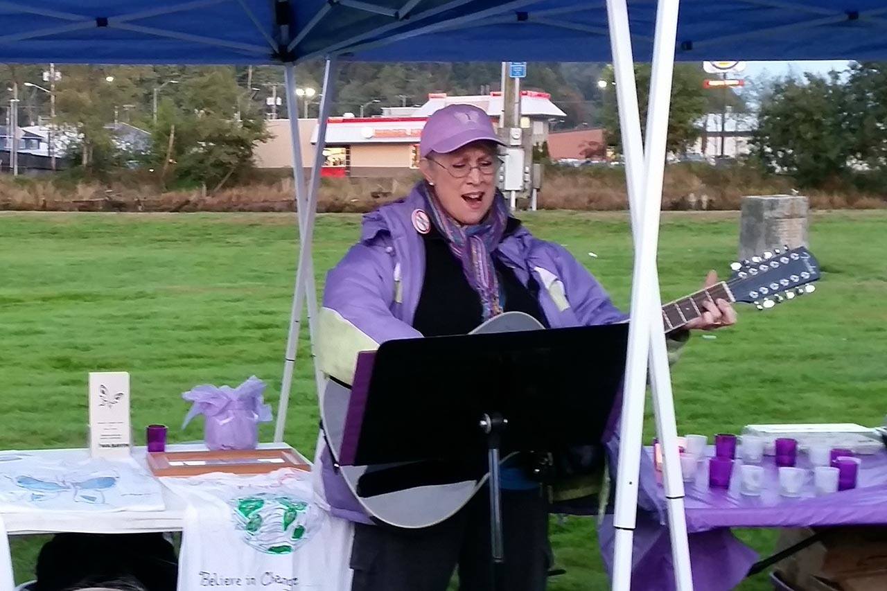 (Terri Harber/The Daily World) Sheranmarie Bachman sings Wednesday during the 4th Annual Domestic Violence Candle Light Vigil held Wednesday at at Zelasco Park in Aberdeen.