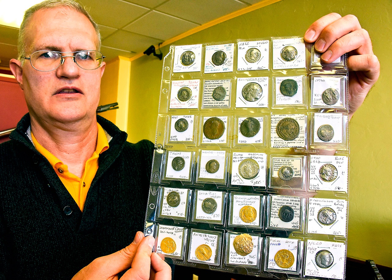 Blaine Shiff holds a group of ancient coins, some of which date back to 400 B.C., at his shop in Dormont. The Federal Trade Commission has issued final rules regarding copies of collectors items. (Darrell Sapp/Pittsburgh Post-Gazette)