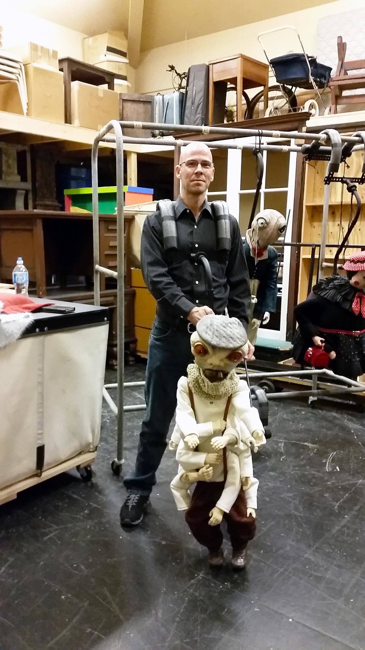 Jason Kramer demonstrates how an actor uses one of the puppets he designed for “James and the Giant Peach.” (Terri Harber|The Daily World)