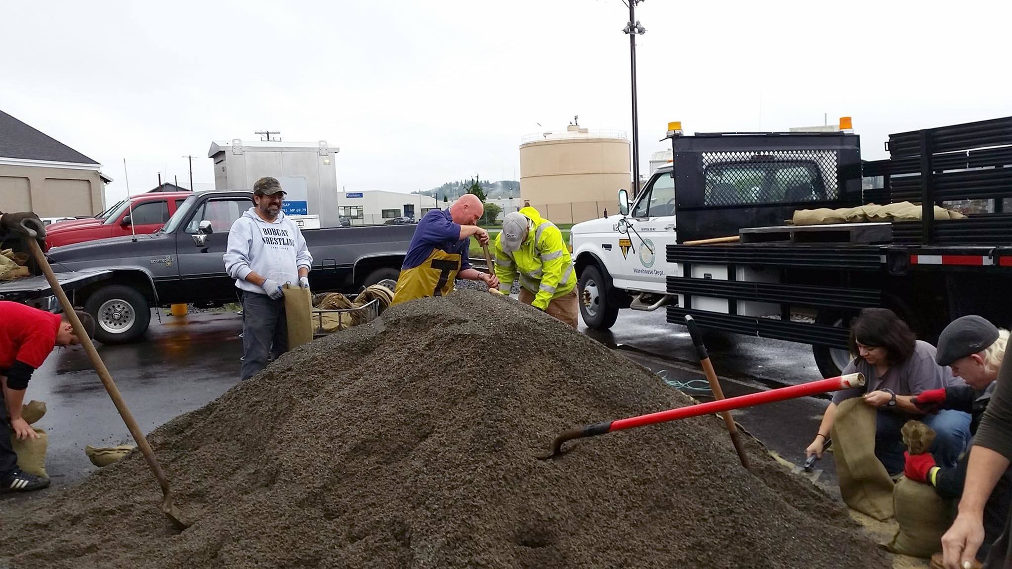 Sal Prieto of Aberdeen, left, holding a sandbag, was among residents and Grays Harbor PUD employees outside of the Aberdeen Water Department filling sandbags Thursday morning in preparation for strong storm conditions through the weekend. (Terri Harber|The Daily World)