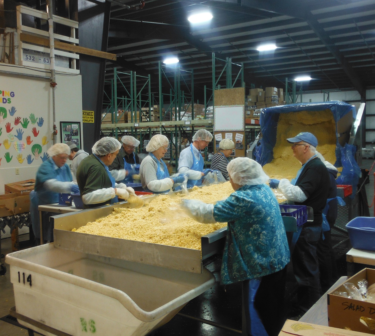 Congressman Derek Kilmer (back row on right) joined volunteers at the Coastal Harvest warehouse in Hoquiam Tuesday morning, bagging up hundreds of pounds of corn for the 40 feeding programs Coastal Harvest serves. State Representative Brian Blake joined in later in the morning. DAN HAMMOCK THE DAILY WORLD