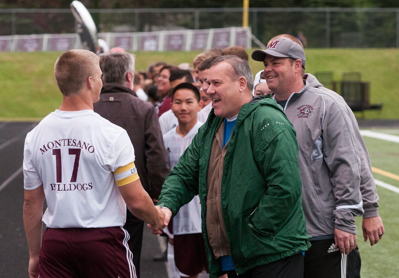 (Brendan Carl | The Daily World) Mike Malpass, seen here shaking Kylar Prante’s hand during the Montesano boys soccer Senior Night ceremonies at Rottle Field in May, passed away on Monday after a long battle with cancer. He was 51.