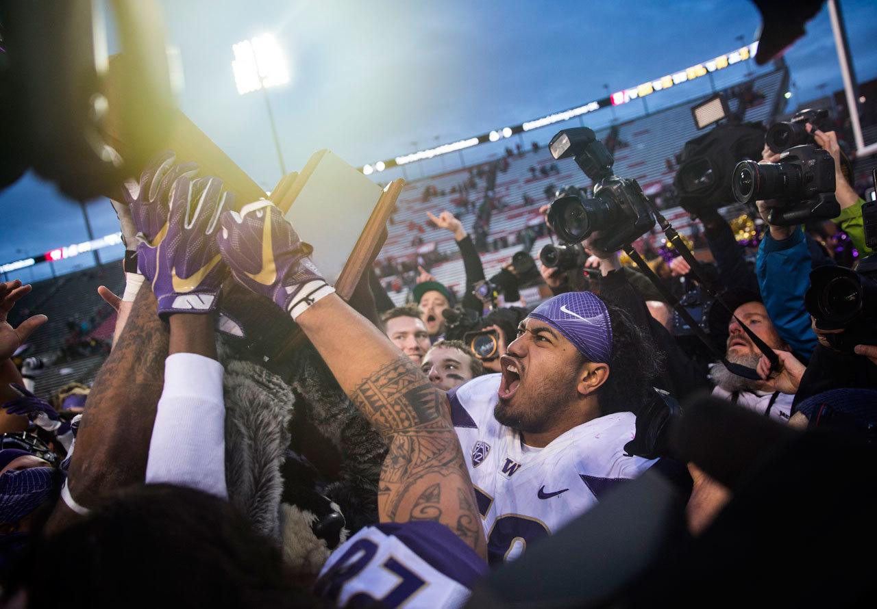 (Lindsey Wasson | Seattle Times)                                Washington defensive lineman Vita Vea cheers as his team receives the Apple Cup trophy after beating Washington State in the 109th Apple Cup at Martin Stadium in Pullman on Nov. 25. Washington won, 45-17.