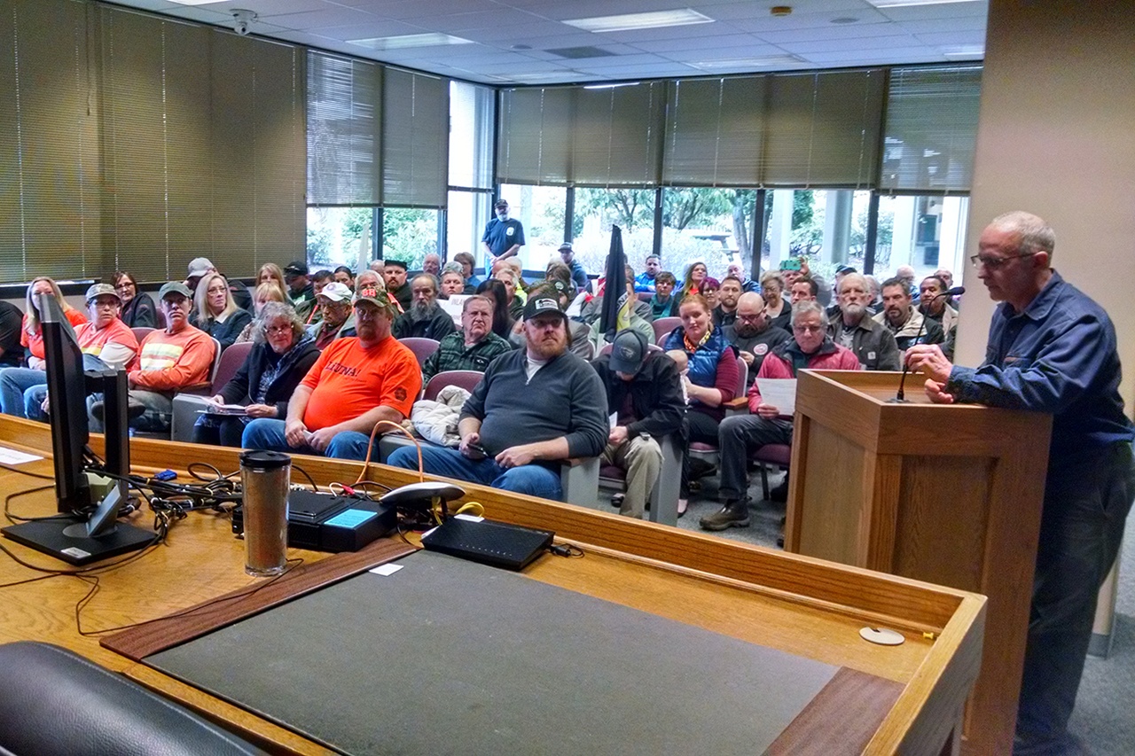 Patrick Wadsworth of Montesano addresses the Grays Harbor County Commissioners as a packed conference room looks on. Wadsworth and a vast majority of the public comments were opposed to a proposed resolution that aimed to make employee contract negotiations public. That resolution ultimately failed. (Corey Morris | The Vidette)