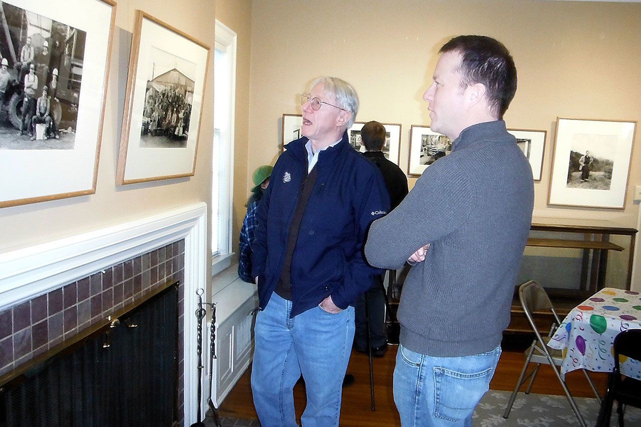 Polson Museum Director John Larson (right) celebrated 20 years at the helm at a reception Sunday at the museum. Here he checks out the museum’s yet-to-open John Tylczak exhibition of photos featuring local loggers in the 1980s with former Daily World editor and current chief historian for the state’s oral history program.