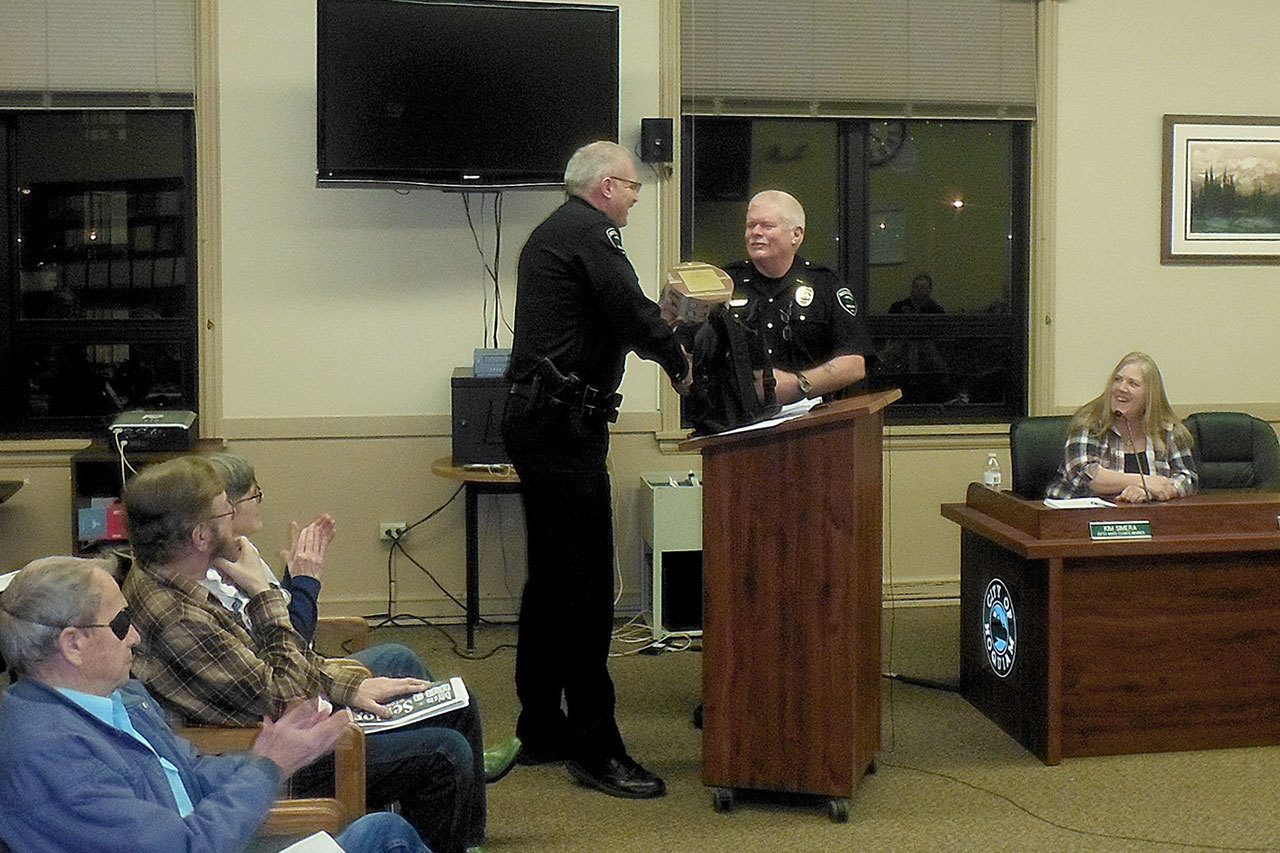 Hoquiam Police Chief Jeff Myers, left, honors Deputy Chief Don Wertanen with a section of the original Hoquiam City Jail for all his work in the recent expansion of the facility. (DAN HAMMOCK|THE DAILY WORLD)