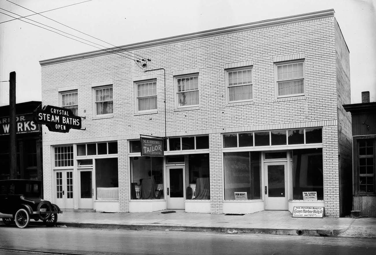 Anderson & Middleton Company/Jones Photo Collection                                The Crystal Steam Bath building in Aberdeen has been knocked down for parking space at the future Gateway Center. This photo, from the Jones Photo Historical Collection, appears to have been taken soon after the building was built in 1928 on the 100 block of South F Street. A tailoring business occupies the middle of the building. The baths are believed to have closed for good in the 1980s. Local historian Roy Vataja remembers going to the Crystal Steam Bath when he was young and shared some memories from his experiences there. “My parents came to Aberdeen from Finland in 1959 and the sauna was, and is, one of main touchstones of Finnish culture. When I was growing up in the early 1970s we would frequently go to the Crystal Steam Baths on a Friday night. There was still a good sized Finnish population on the Harbor at that time and the owners, Rudy and Marge Kauhanen, were friends of the family. I remember how clean everything was. We’d go into the dressing room and then into the sauna. The upper deck was warmest and my dad would make sure that I always started out on the top deck and he would let the steam pour. I would stand it for as long as I could to prove how ‘tough’ a 7-year old I was, but eventually would have to move to the lower, cooler deck. Afterwards, we would cool off in the dressing room with my parents enjoying cans of Oly beer while I clutched my bottle of Simba soda. I really miss those days and although I did get to go into the building a few months ago, I much prefer remembering how it was.”