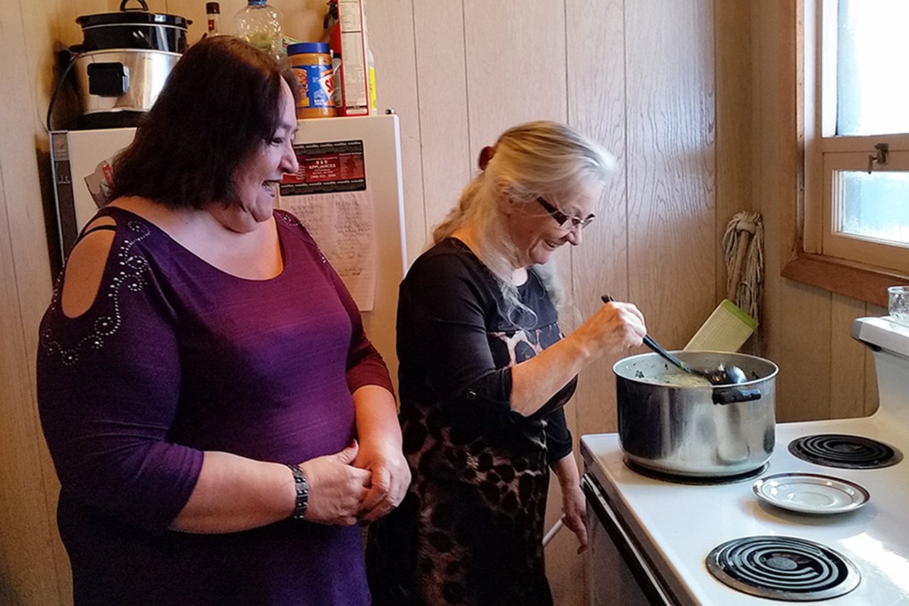 Linda Cazier watches Becky Davenport stir a pot of Menudo Friday afternoon at Esther House. Cazier is a pastor at the church and is Jennifer Chuks Nwokike’s mother. Davenport teaches Bible school, also at the church. Both women devote time to the shelter. (Terri Harber|The Daily World)