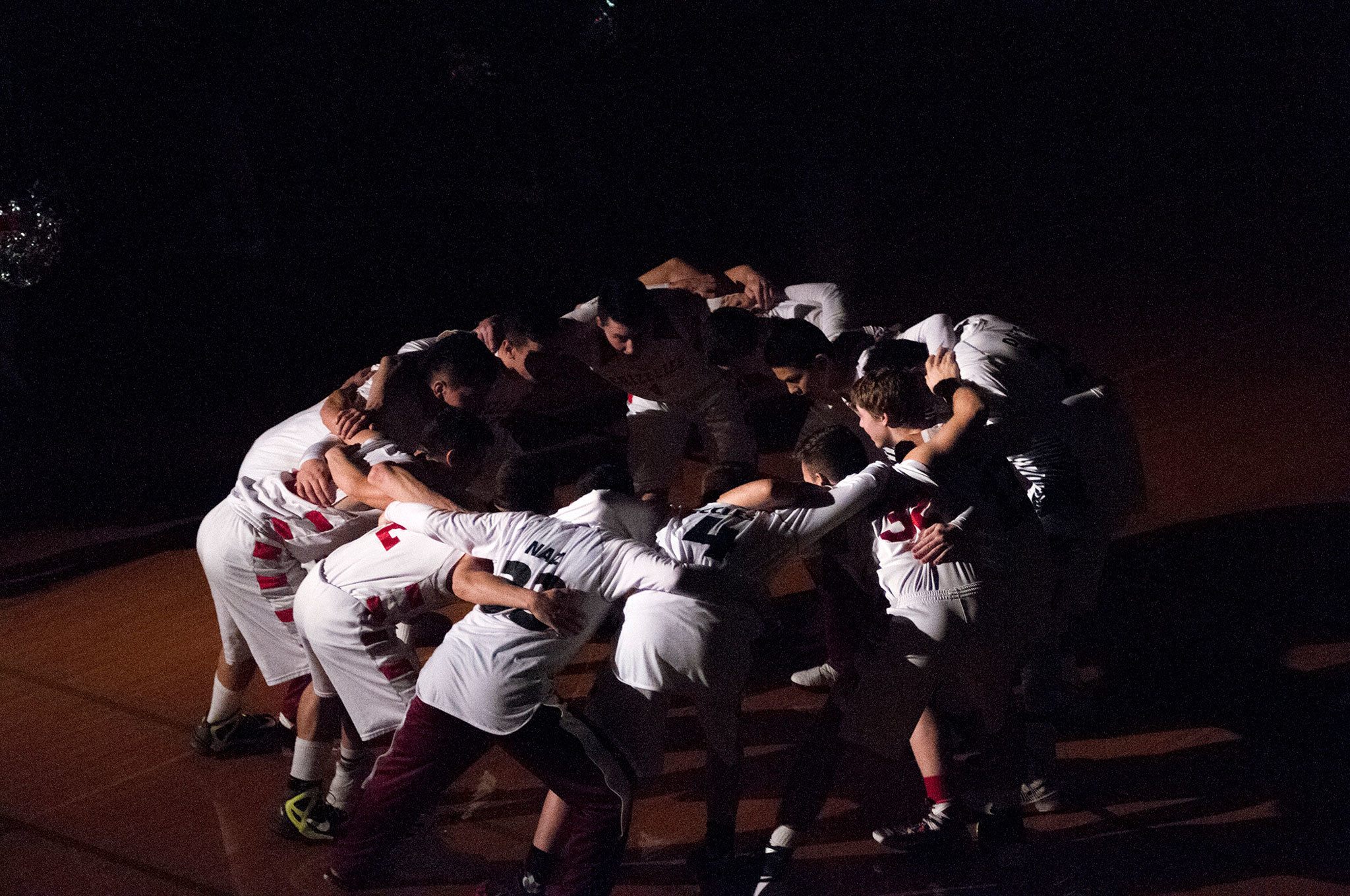 (Brendan Carl | The Daily World) Hoquiam’s boys varsity basketball team huddles up in the dark before its takes the court against Tumwater at Hoquiam Square Garden in December.