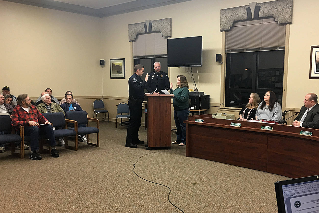 Hoquiam Mayor Jasmine Dickhoff swears in new Hoquiam Police officer Rob Verboomen at the beginning of the Hoquiam City Council Monday evening. Hoquiam Police Chief Jeff Myers is in the background.