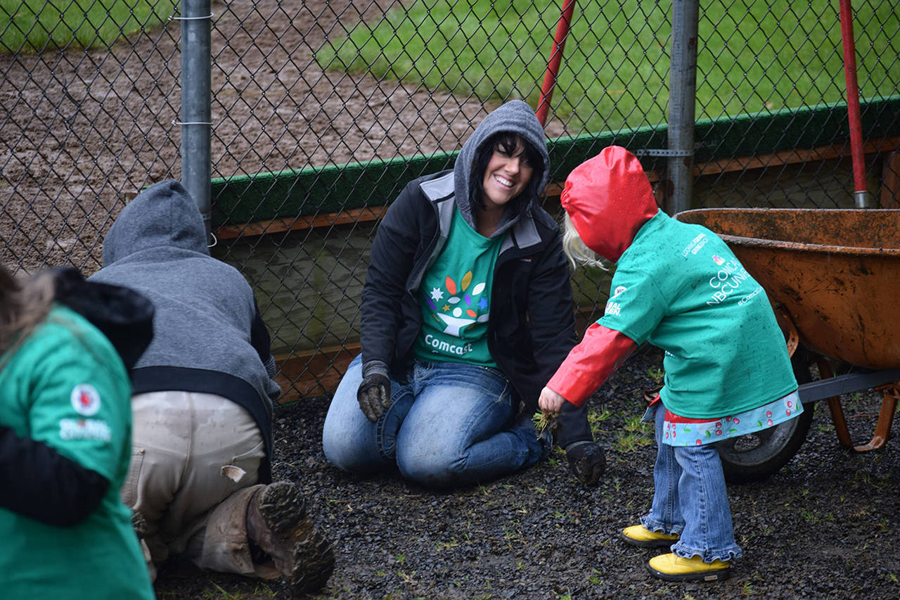 Hoquiam City Council member Logan Livingston, who had a young helper, was among the city officials who showed up to share their support and to volunteer on Comcast Cares Day.