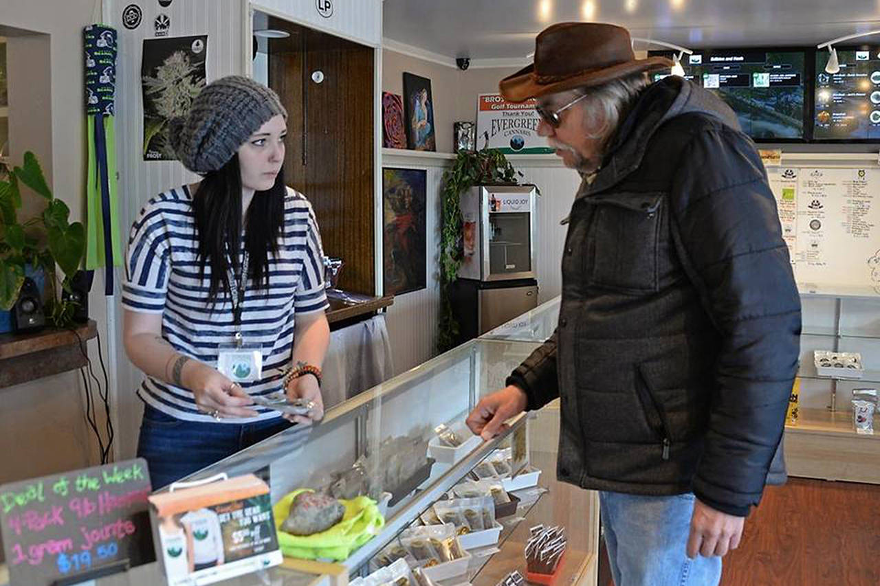 Jessica Leppala, left, helps customer Dave Watters on Monday at Evergreen Cannabis in Blaine. (Philip A. Dwyer/Bellingham Herald)
