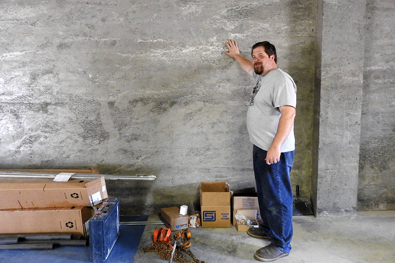 Kat Bryant | The Daily World                                Rob Paylor, a partner in Hoquiam Brewing Co., shows off the concrete walls he sanded himself. “I probably couldn’t have paid somebody to do as much work as we did to these walls,” he says.