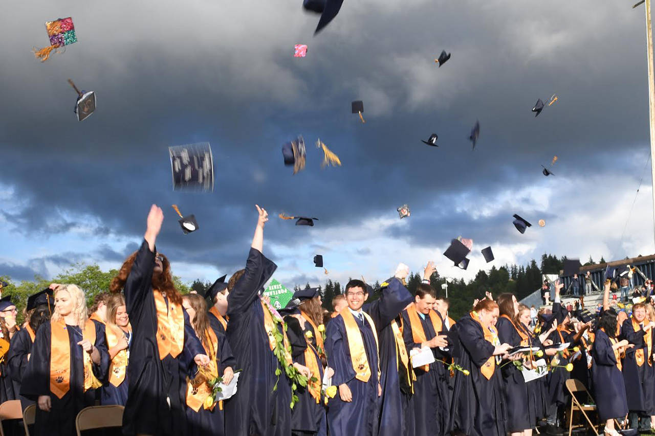 Aberdeen High graduates toss their mortar boards into the air to celebrate the end of their high school careers Friday night at Stewart Field. (Photo by Matthew Coyle)