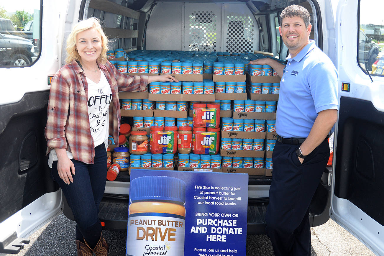 DAN HAMMOCK | THE DAILY WORLD                                Thousands of pounds of peanut butter were collected during Five Star Ford’s month long Ford Focus on Hunger peanut butter drive. On the left is Coastal Harvest Executive Director Angela Burton, on the right is Five Star Ford General Manager Damon Gleason.
