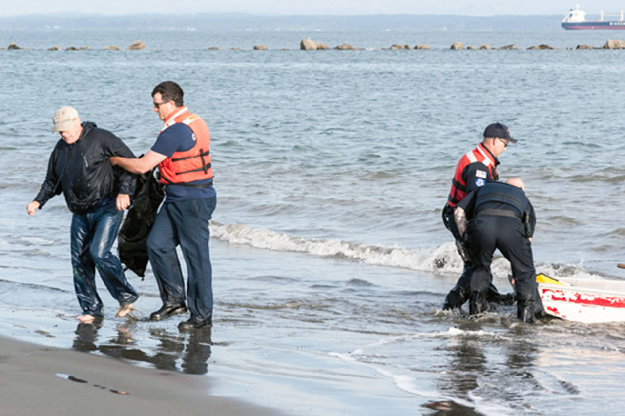 Ocean Shores Fire Department photo: Jim Brannan is helped onshore by police and fire department officers who arrived to help him on June 6.
