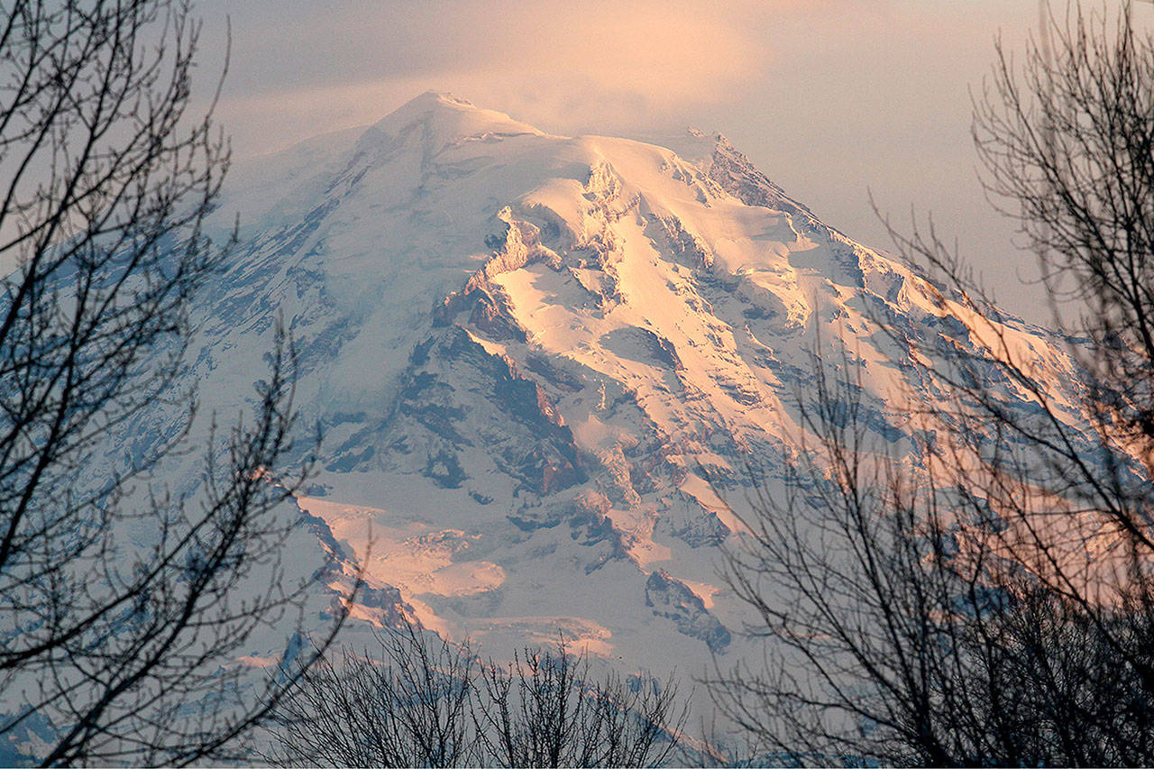 Mount Rainier at dusk. Interior Secretary Ryan Zinke says he’ll ease the impact of potentially huge National Park Service budget cuts by shifting more resources to the “front line,” but offers little detail. (Ellen M. Banner/Seattle Times)