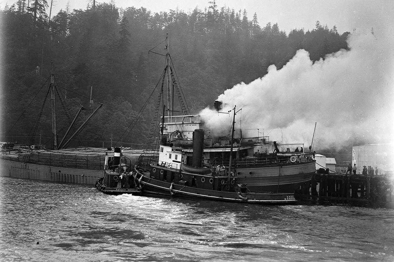Smoke billows from the engine room of the City of Nome, soon after a blaze began on the afternoon of June 3, 1927 at the Standard Oil Dock (present day location of Lakeside Industries). The harbor tug Ranger and the larger ocean-going tug Tyee aided in crucial work by moving the City of Nome away from the fuel tanks and preventing a potentially deadly explosion. Note that the road over the bluff had not yet been constructed. In 1927 the main road in and out of Aberdeen ran along what is now the Morrison Park walkway. (Jones Photo Historical Collection)