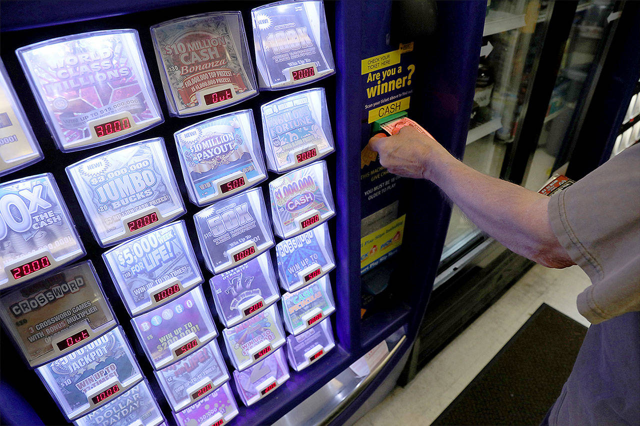 A customer pays for scratch out tickets from a vending machine at the Harwood Convenient Store in Harwood, Ill., on June 28. (Antonio Perez/Chicago Tribune)