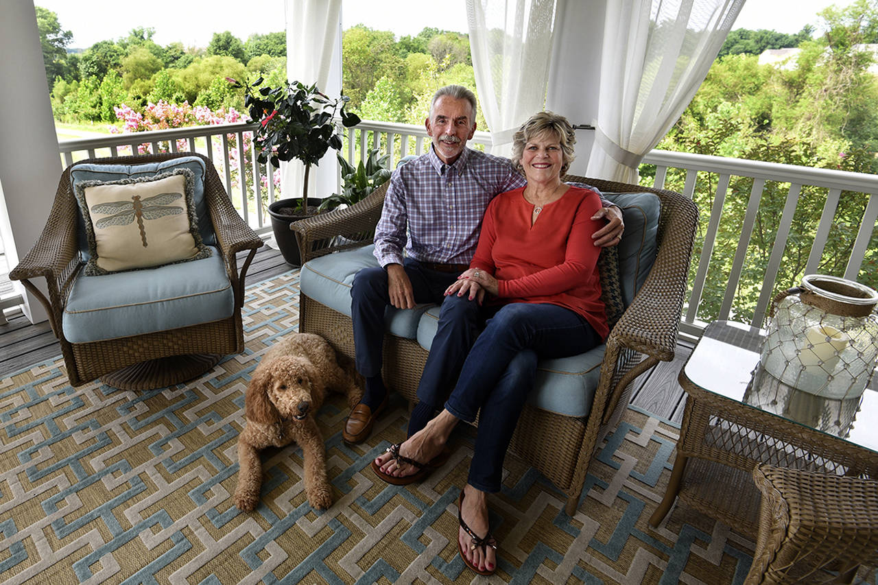Algerina Perna | Baltimore Sun                                 Corky and Anne Franklin in their dream home with their goldendoodle, Hudson.