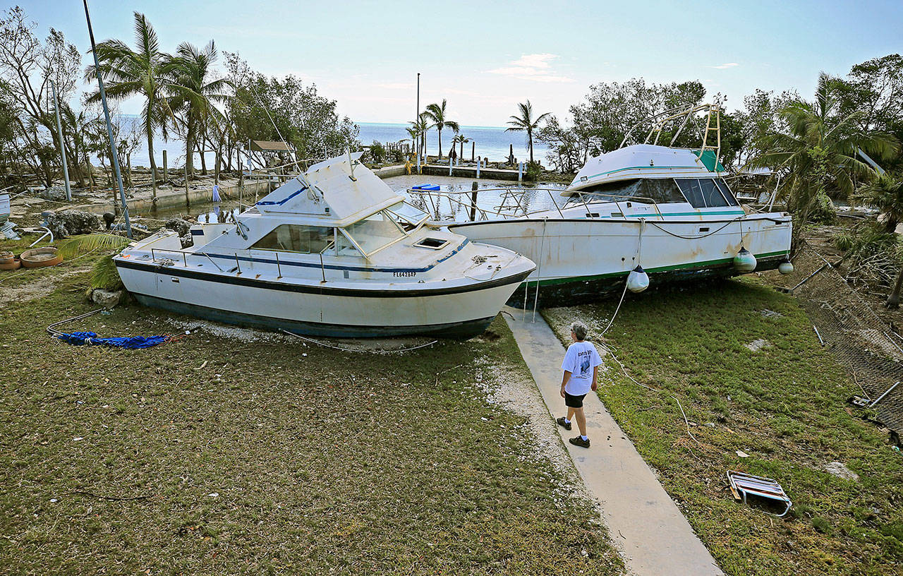 Chris Morgan inspects the large boats that beached onto the property she in stayed during Hurricane Irma’s storm surge in Key Largo, Fla., on Tuesday. (Al Diaz/Miami Herald)