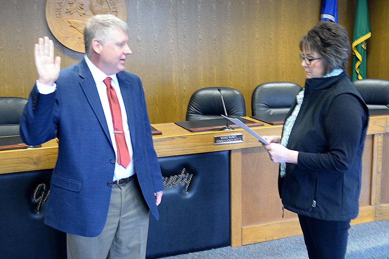 DAN HAMMOCK | THE DAILY WORLD                                Chris Thomas of Montesano is sworn in to office by Grays Harbor County Commissioner Vickie Raines Monday afternoon. Thomas was selected by the commission to fill the County Auditor position left vacant when Vern Spatz retired at the end of August after 28 years in office.
