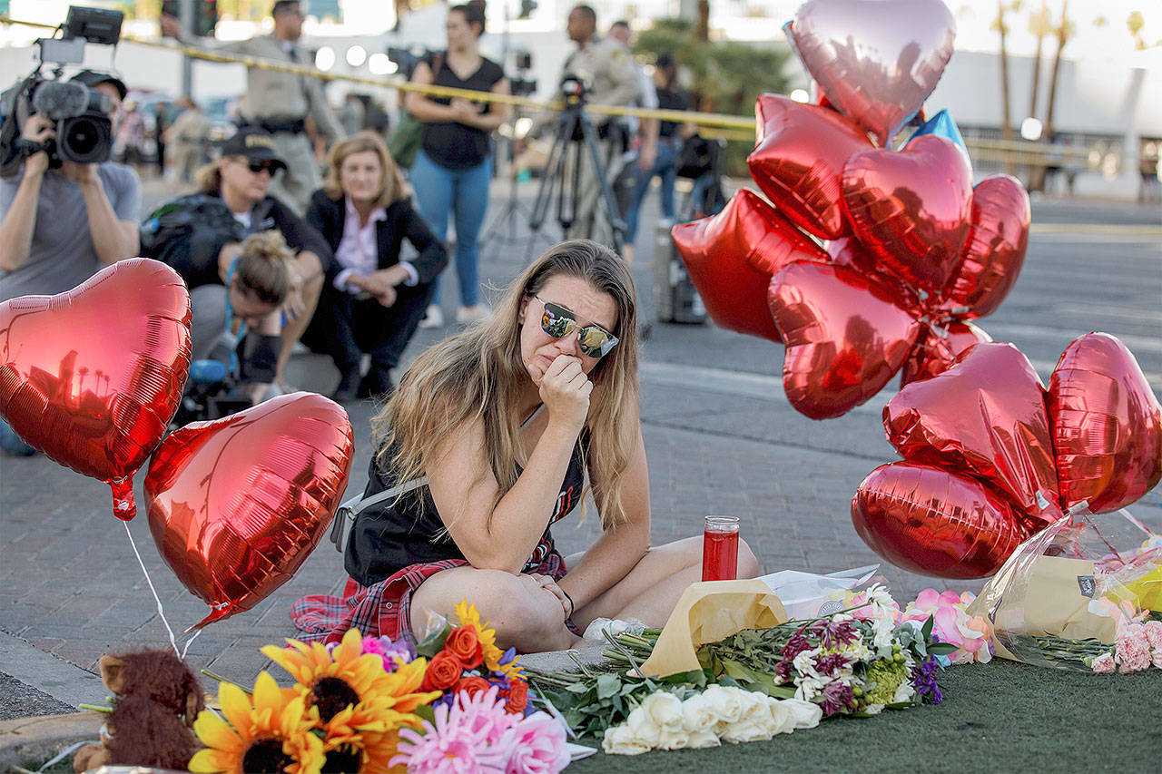 Destiny Albers weeps at a makeshift memorial on Las Vegas Blvd and Reno Ave for the victims of the recent mass shooting in Las Vegas. Albers attended the Route 91 Harvest Festival concert during the attack on Sunday night and one of her friends was struck down by gunfire. (Marcus Yam/Los Angeles Times)