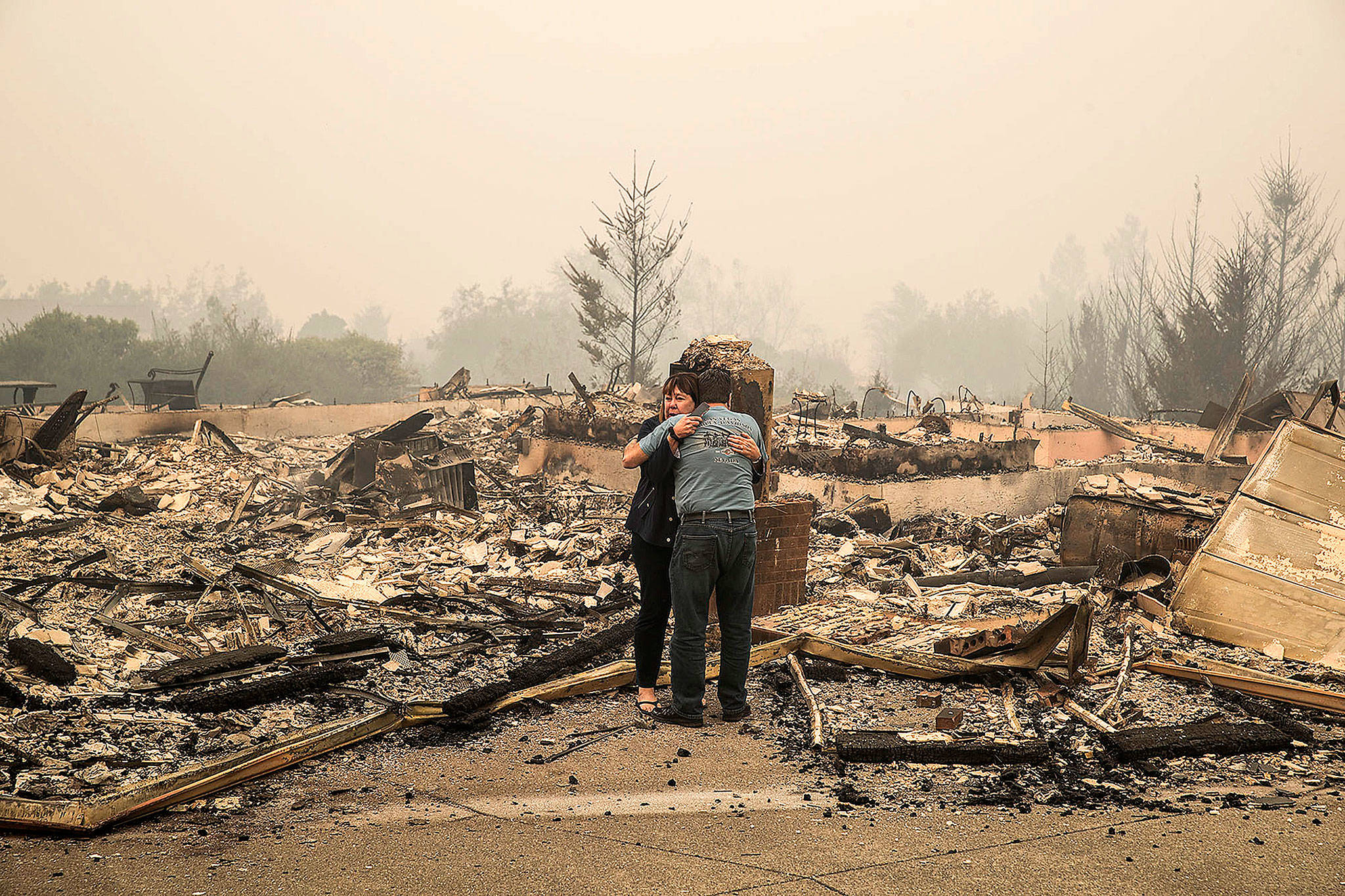 Penny Wright weeps with husband Edward after arriving at their Fountaingrove home of 10 years to find it was completely destroyed in the the Monday morning inferno in Santa Rosa, Calif. (Brian van der Brug/Los Angeles Times)