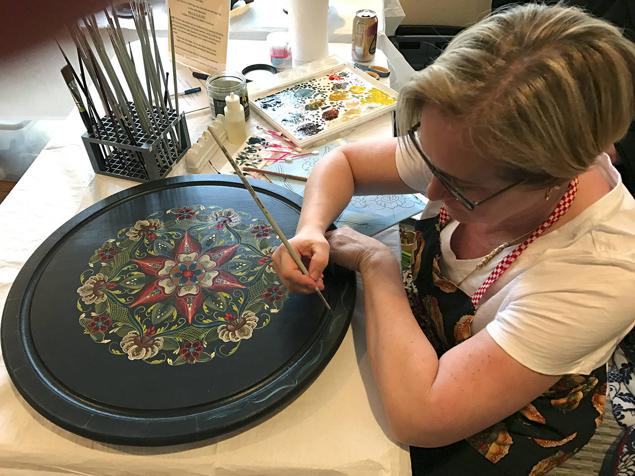 photos Courtesy Kristin Sullivan                                A rosemaling artist demonstrates her work in Bothell during Nordic Heritage Day in March. This form of decorative art originated in the lowland areas of Eastern Norway. Though most often a style of painting, rosemaling appears in carved wood as well.