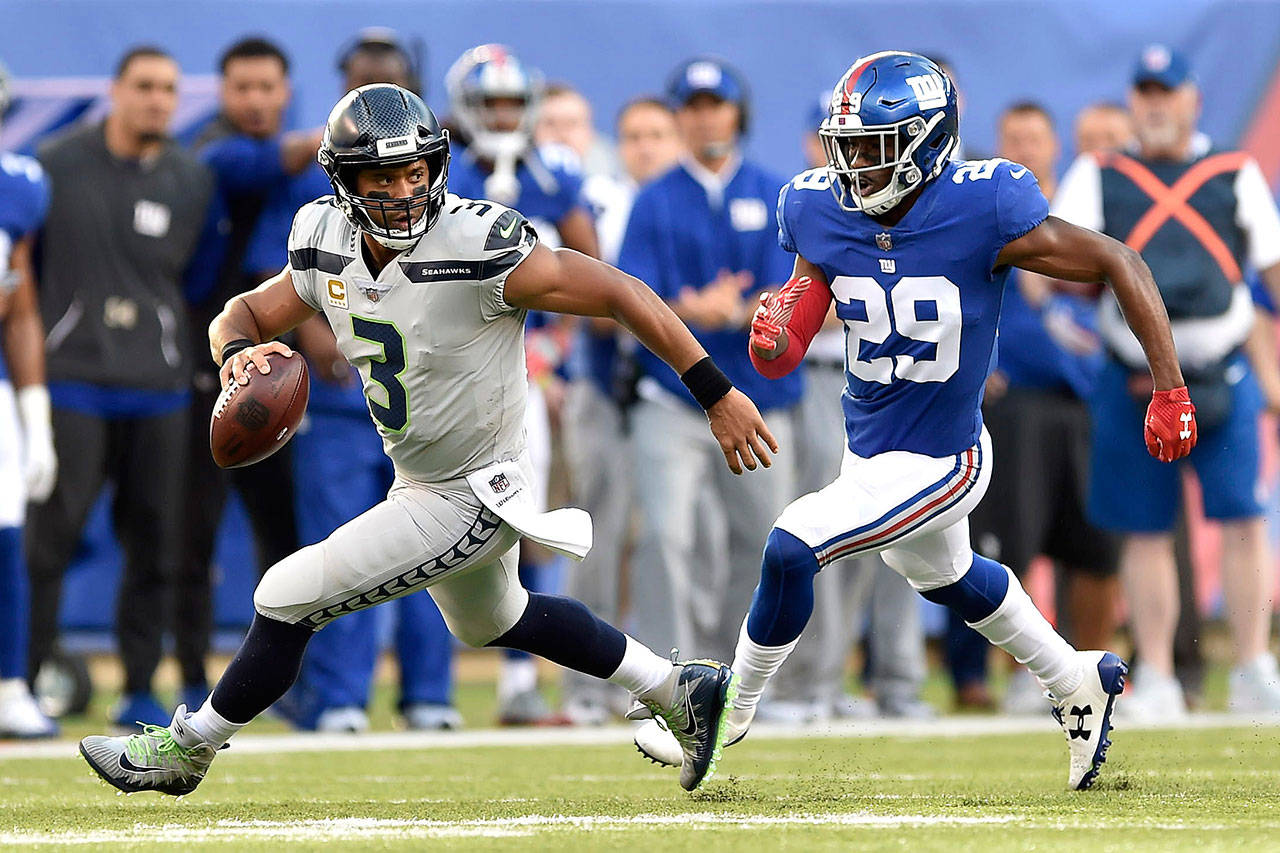 Seattle quarterback Russell Wilson tries to evade the tackle of New York safety Nat Behre at MetLife Stadium in East Rutherford, New Jersey, on Sunday. (Brooks Von Arx | ZUMA Wire)