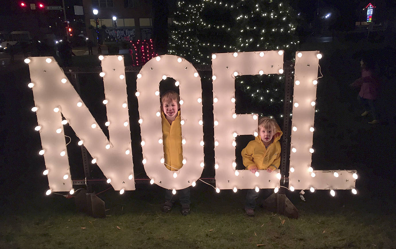 Emmet and Ansel Quigg, sons of David Quigg, peer through the large Noel sign that was lit up along with the Christmas tree on the first day of the 2016 Aberdeen Winterfest. This year there will be two tree lightings - one Dec. 1 in Zelasko Park, and another at the Grays Harbor Historical Seaport Dec. 2.