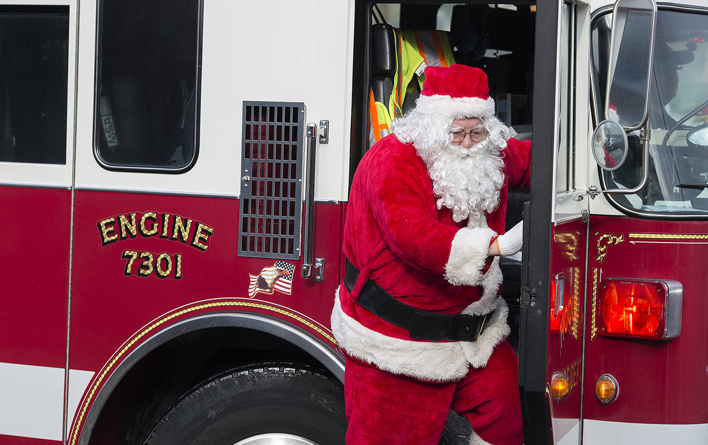 DAILY WORLD FILE PHOTO                                 Santa climbs from a Hoquiam fire truck to greet the hundreds of locals who gathered at Central Elementary School in Hoquiam as part of a previous year’s Ho Ho Hoquiam celebration. He will show up Saturday at 11 a.m. for pictures and every child who attends gets a toy and bag of candy.