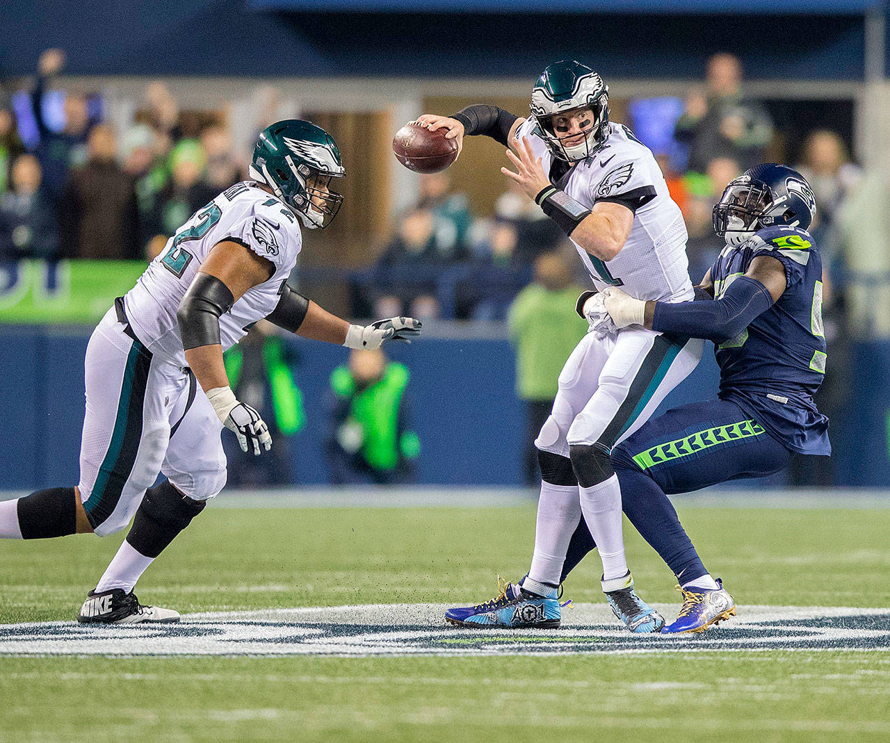 Seattle Seahawks defensive end Frank Clark brings down Philadelphia Eagles quarterback Carson Wentz during first-quarter action on Sunday at CenturyLink Field in Seattle. (Mike Siegel/Seattle Times)