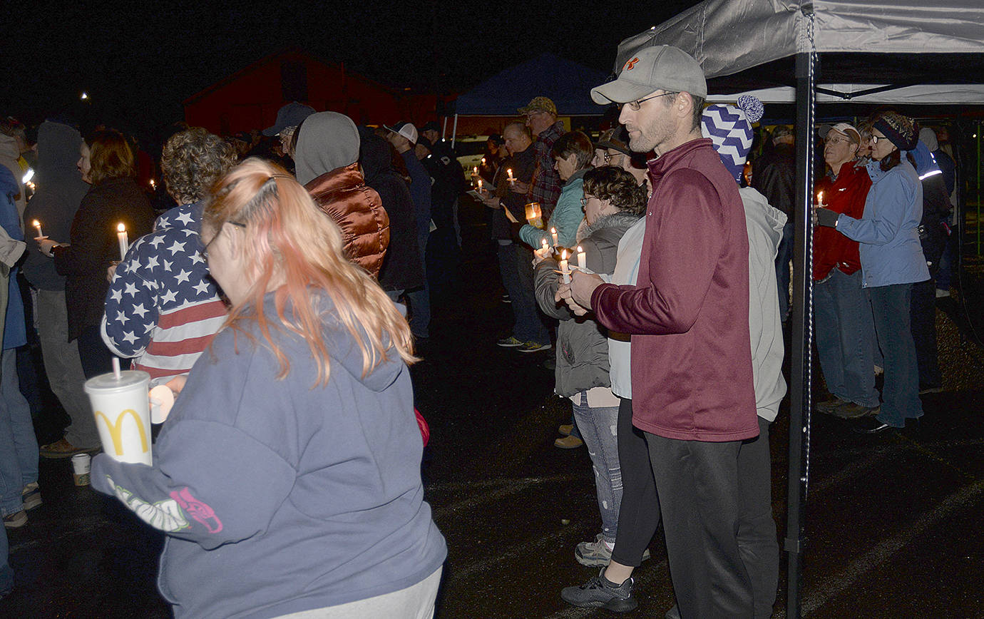 DAN HAMMOCK | THE DAILY WORLD                                Law officers from Pierce, Grays Harbor and Pacific counties joined in with community members to honor former Hoquiam Police officer Daniel McCartney at a candlelight vigil outside the Hoquiam Police Department Tuesday evening.