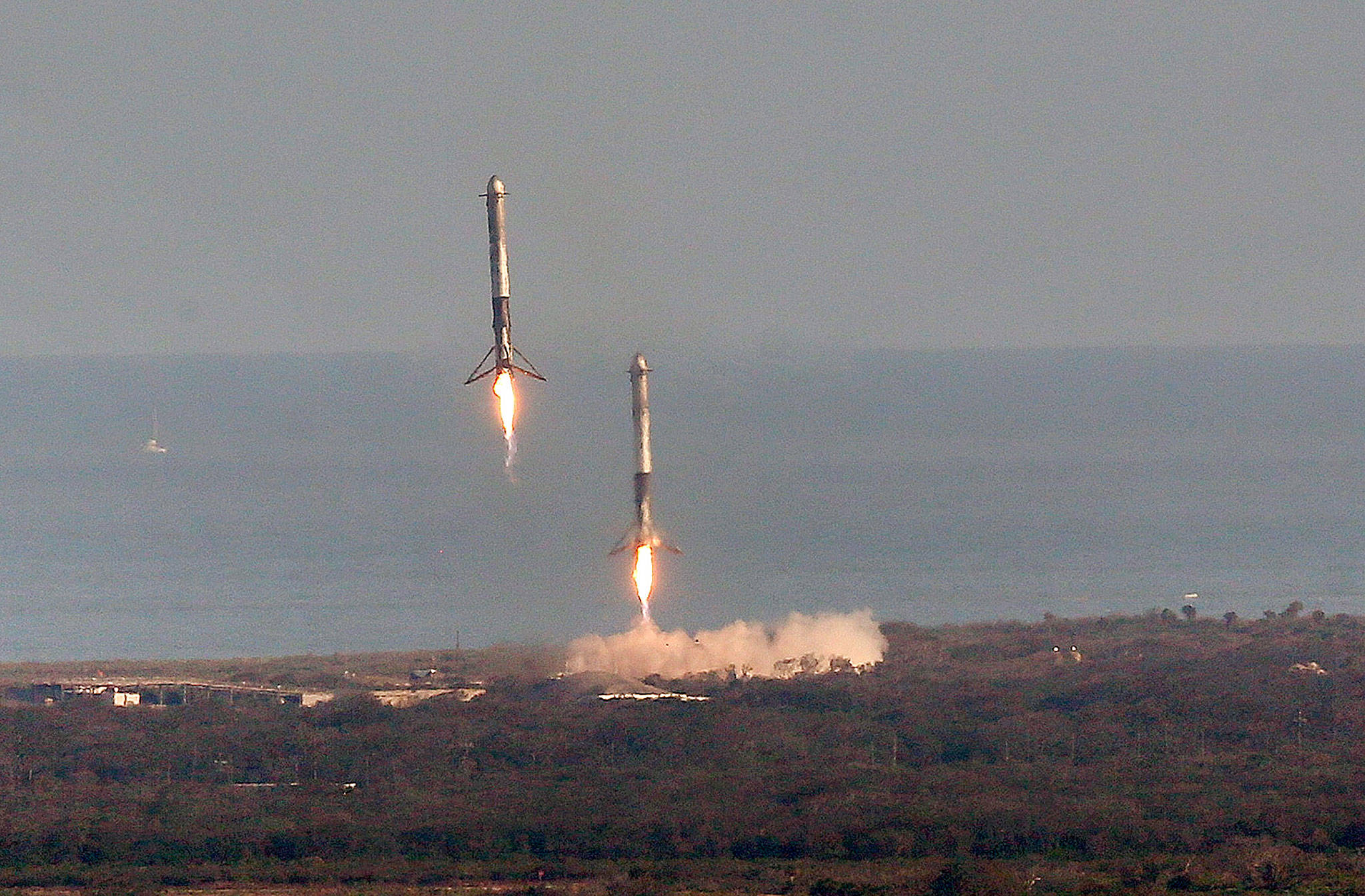 Two Falcon boosters come back to land at Cape Canaveral after SpaceX’s Falcon Heavy rocket lifted off from launch Pad 39A Tuesday for the maiden demonstration test flight at the Kennedy Space Center. The big rocket is made up of three rocket boosters that will produce more thrust than any other rocket now flying. (Red Huber/Orlando Sentinel)