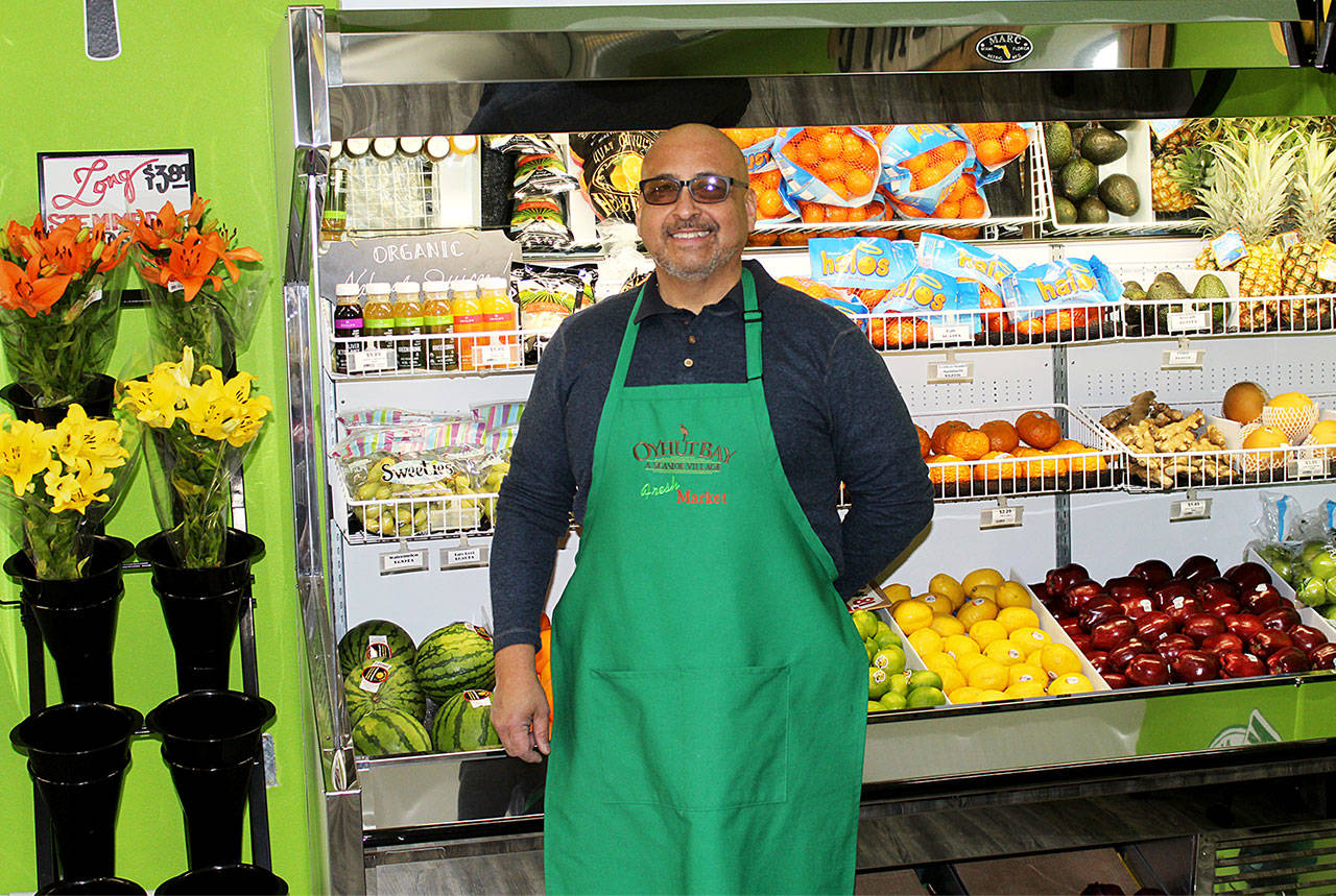Angelo Bruscas/North Coast News                                Carlos Villarreal gives a tour of the fresh fruits, vegetables and flower section of the new Fresh Market at Oyhut Bay.