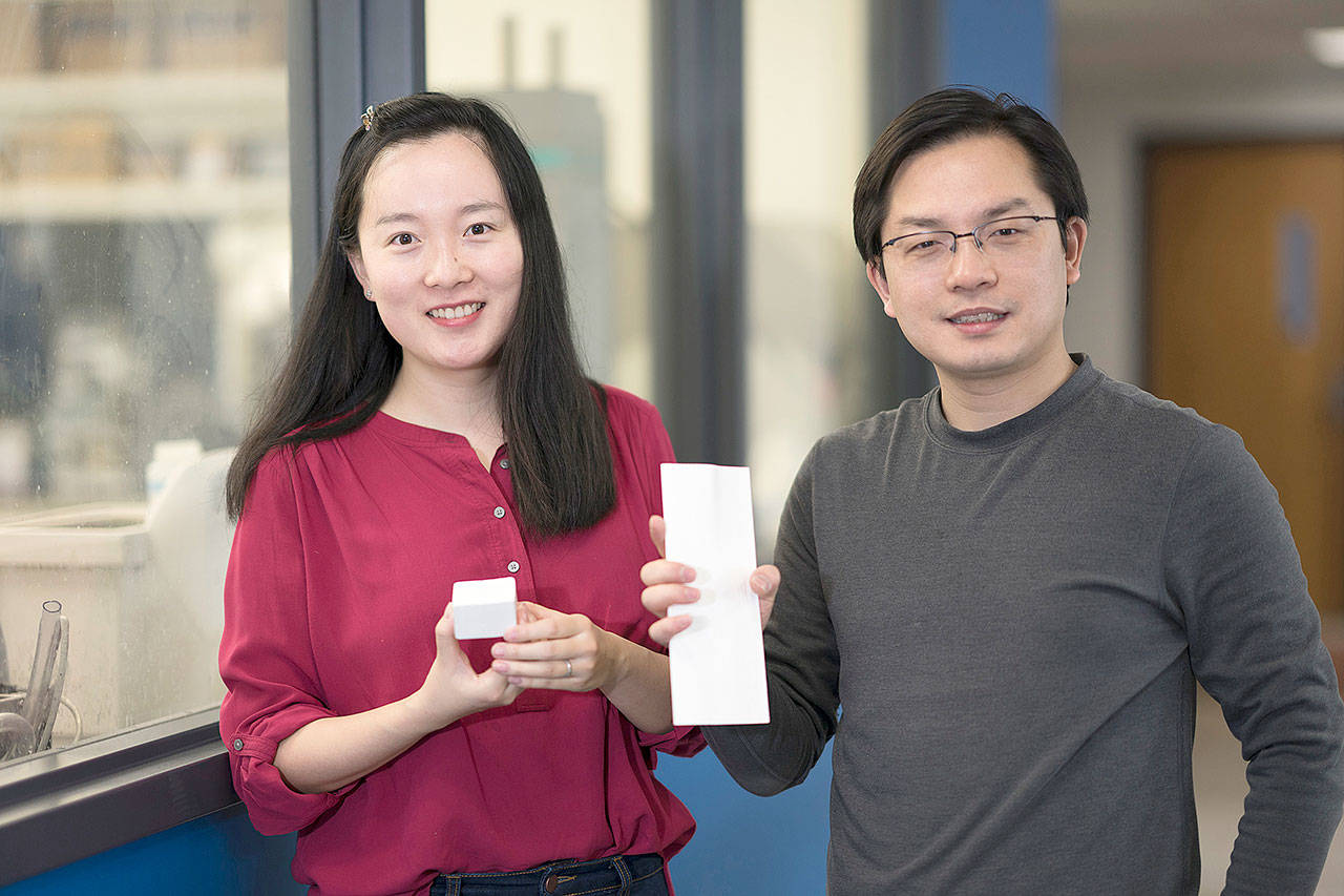 Tian Li, left, and Liangbing Hu hold pieces of nanowood, a strong, lightweight material that serves as an effective insulator. (Hua Xie/University of Maryland)