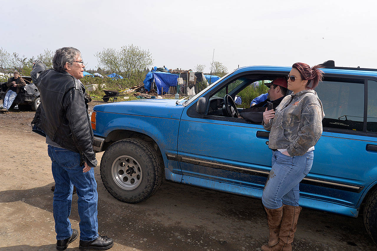 LOUIS KRAUSS | THE DAILY WORLD Charles Feick (left), who President of Green Harvest Cannabis and is working with Sam Hutchinson to assist in finding homes and cleaning out the riverfront homeless camps in Aberdeen, speaks with Revival of Grays Harbor President Emily Reed.
