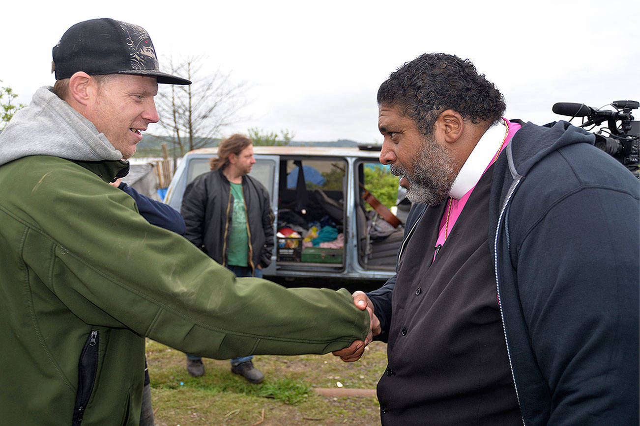 LOUIS KRAUSS | THE DAILY WORLD Rev. Dr. William Barber II meets with a homeless camper along the Chehalis River in Aberdeen. This was his last stop on a nationwide tour of select impoverished communities as part of the Poor People’s Campaign.