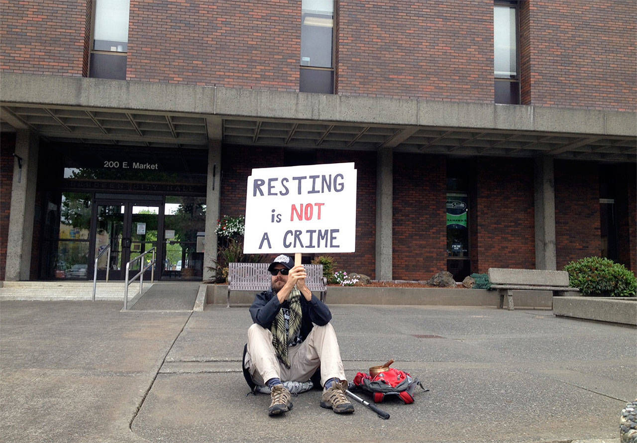 (Blind Justice Facebook page) Aberdeen resident Mike Nelson protests a new ordinance that criminalizes sitting and lying down on the sidewalk during the daytime in downtown Aberdeen. He was sitting there for most of Friday and Saturday.