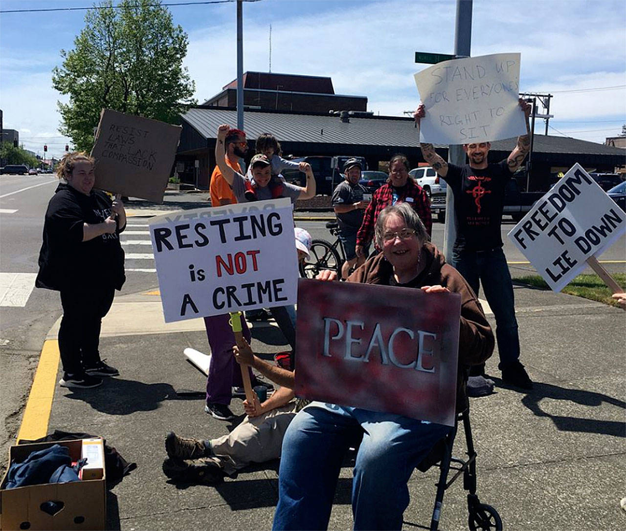 (Facebook) Local citizens protest the new ordinance that prohibits sitting on the sidewalk in downtown Aberdeen. For most of the past two days, Mike Nelson has been sitting on the sidewalk to protest what he says is an unconstitutional rule that unfairly targets homeless people.