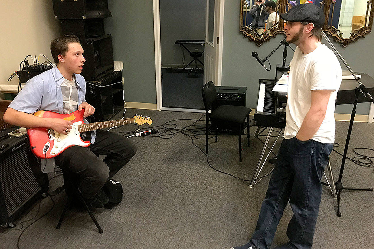 LOUIS KRAUSS | THE DAILY WORLD JR Lakey, right, director of The Garage: Music & Arts Center, gives advice to guitar student Chris Rondon at a jam session two weeks ago.