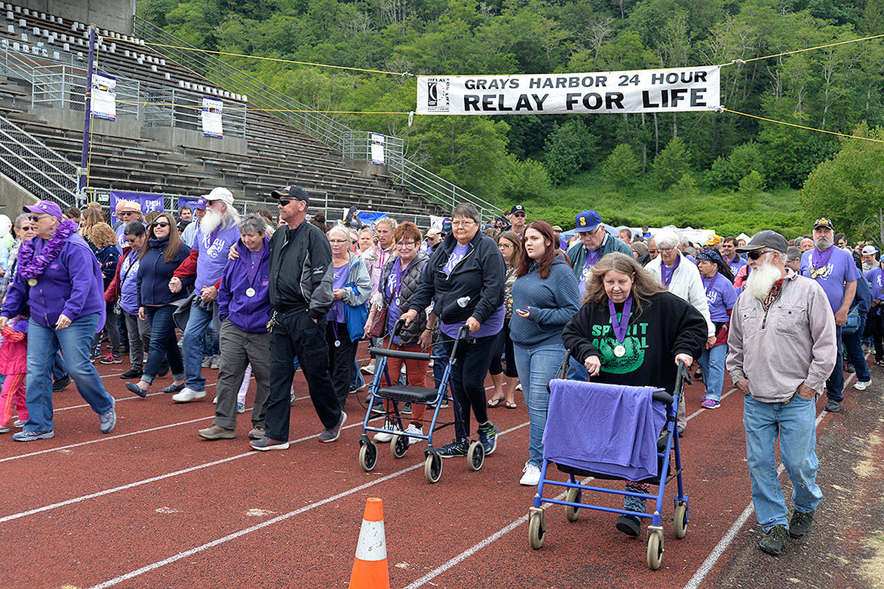 LOUIS KRAUSS | THE DAILY WORLD Cancer survivors begin walking the first lap at the Relay for Life event at Hoquiam High School on Friday.