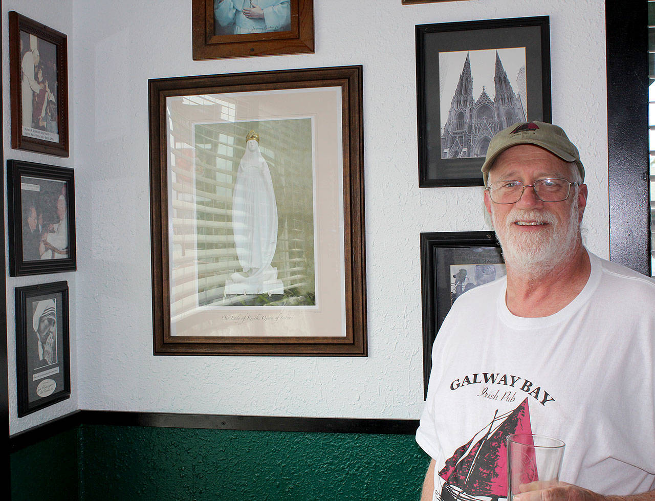 ABOVE: Galway Bay Irish Pub owner Liam Gibbons asks: “Who has an autographed picture of a saint in their banquet room?” Among his collection of papal portraits and other Catholic artifacts, he points to a signed photo of Mother Teresa (at bottom left).                                RIGHT: Sports memorabilia of all things Irish are displayed in the game room at Galway Bay.