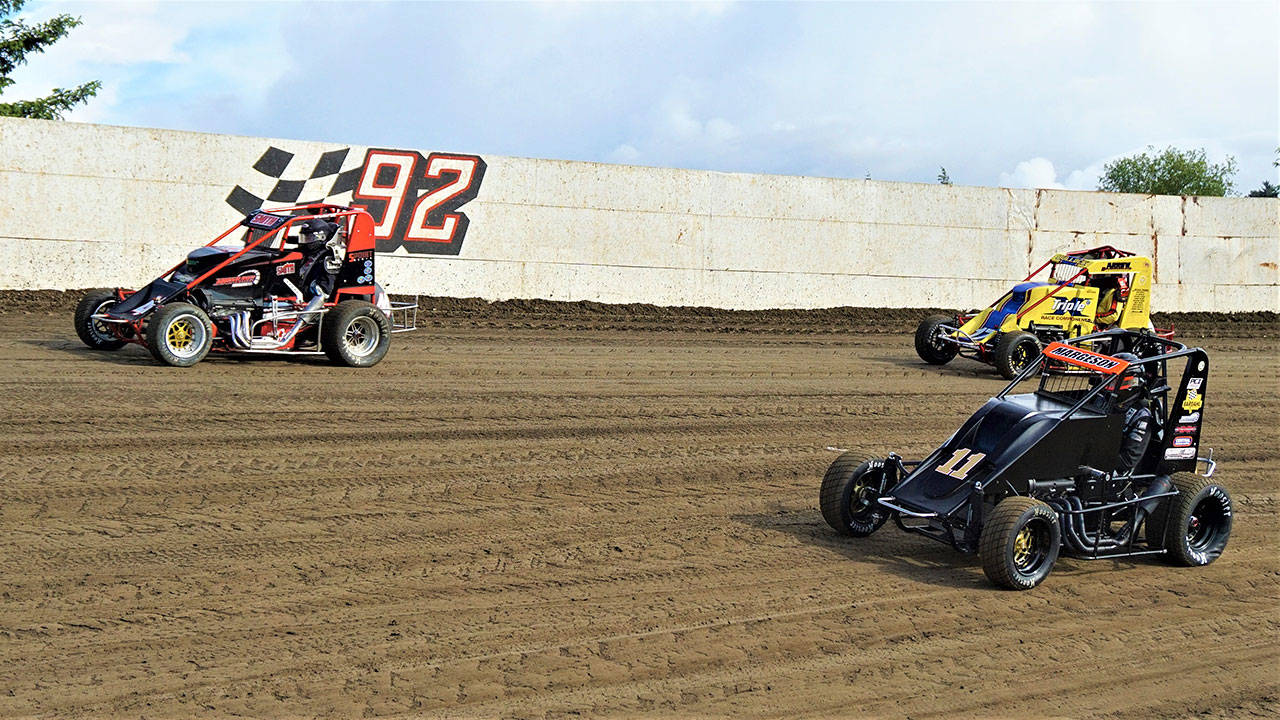 Evan Margeson (11) takes inside position against Shane Smith (44) and Chris Bullock in a Northwest Focus Midgets Series race at Grays Harbor Raceway in Elma. Margeson won the midgets main event feature race. (Photo by AR Racing Videos)