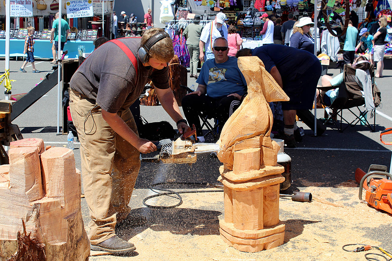 ABOVE: A chainsaw artist puts the finishing touches on a custom-carved pelican at last year’s Sand & Sawdust Festival. More chainsaw artists will be featured this year, with more than 100 wood sculptures to be created on-site to be auctioned to the public.                                RIGHT: Justin the Circler views his creative beach art using a drone. He will be back this year, teaching the art of “geo-scribing” on the beach.                                File photos