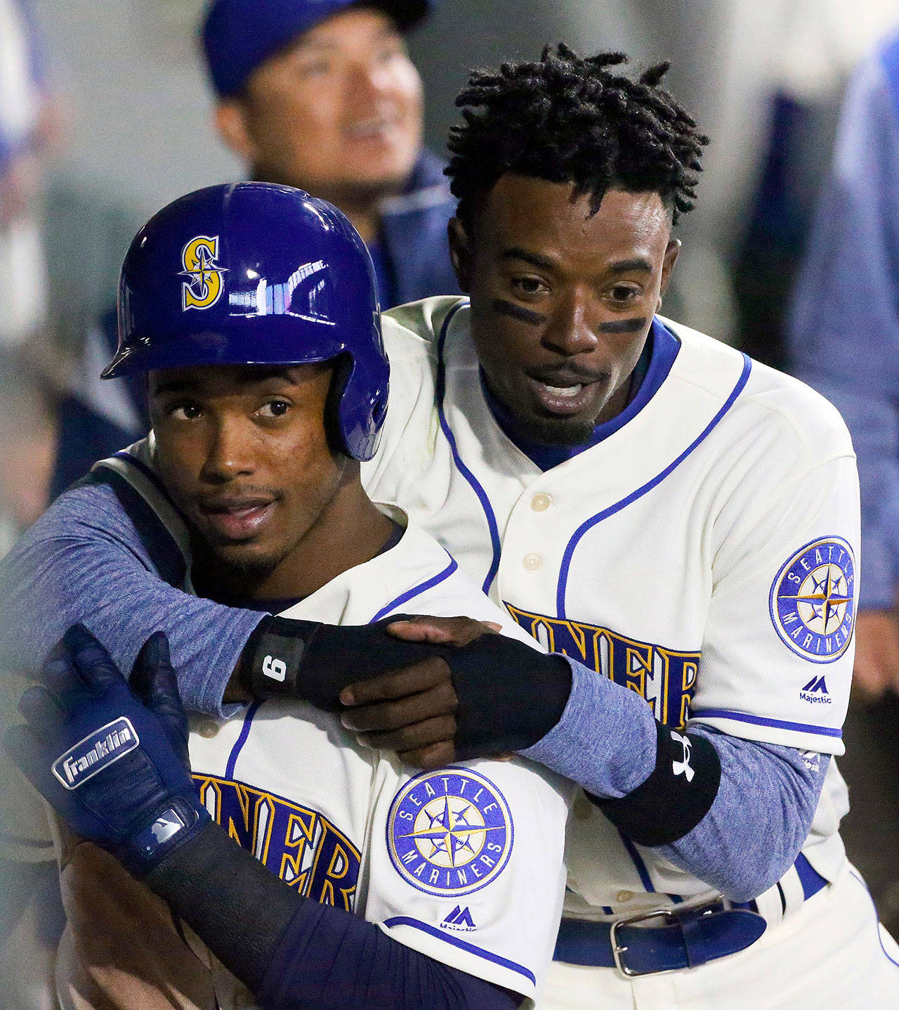 The Seattle Mariners’ Dee Gordon, right, hugs teammate Jean Segura in the dugout during a game in April. Segura has been out of the Mariners lineup since Thursday due to an infection. (Ken Lambert/Seattle Times/TNS)
