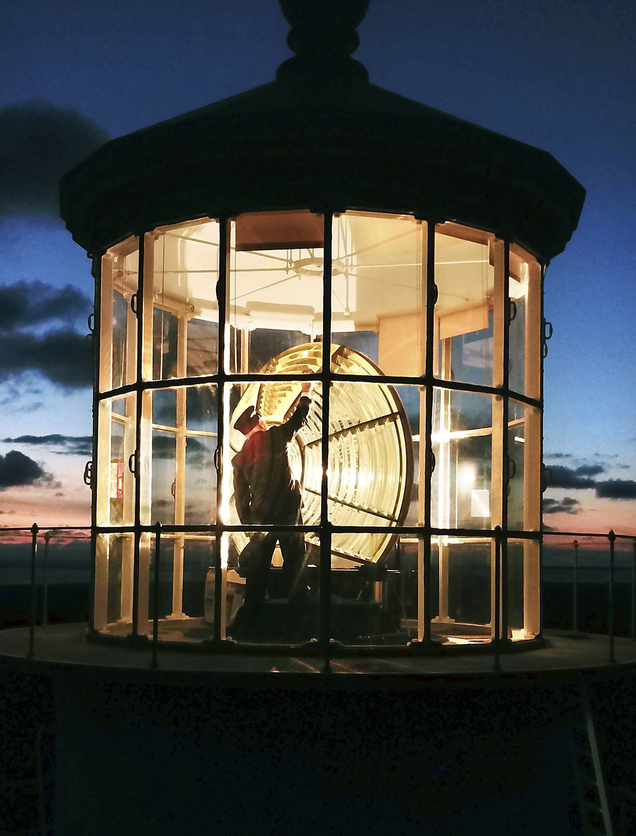 Photo by Pete Lerro                                Jeff Pence, a member of the Westport-South Beach Historical Society, cleans the Fresnel lens wearing traditional keeper’s garb.