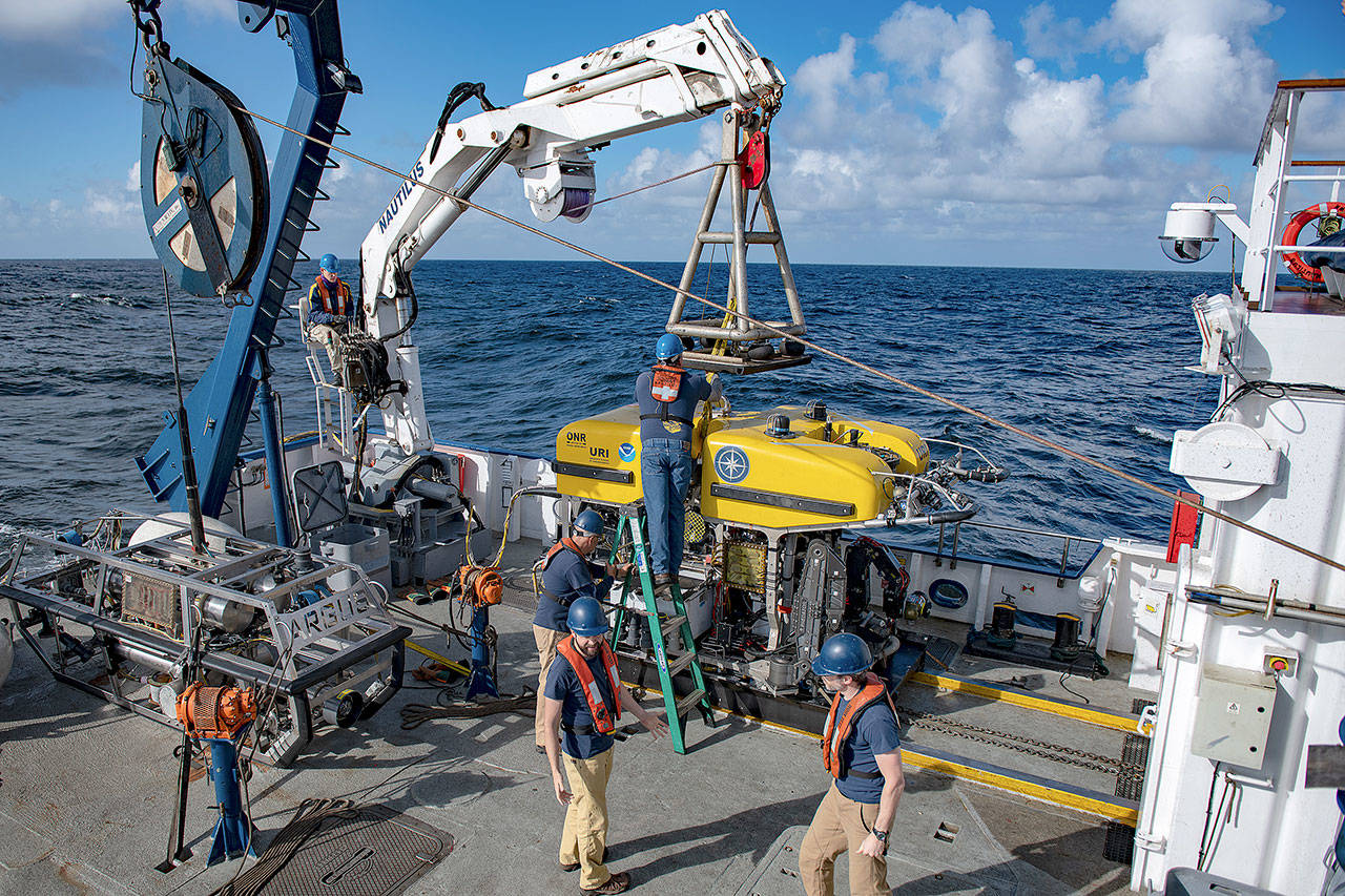 (Susan Poulton/Ocean Exploration Trust) Staff aboard the Nautilus exploration ship prepare to place a remote controlled vehicle into the ocean to search for meteorites that fell in March.